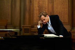 Pianist David Ebner leaning on piano