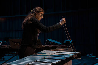 Female percussionist playing vibraphone with bow.