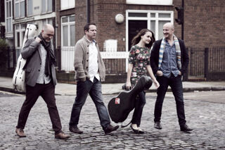 The VIDA Guitar Quartet walking along a cobbled street