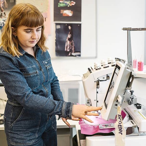 Student by embroidery machine