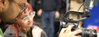 Student being shown how to use a camera on media placement