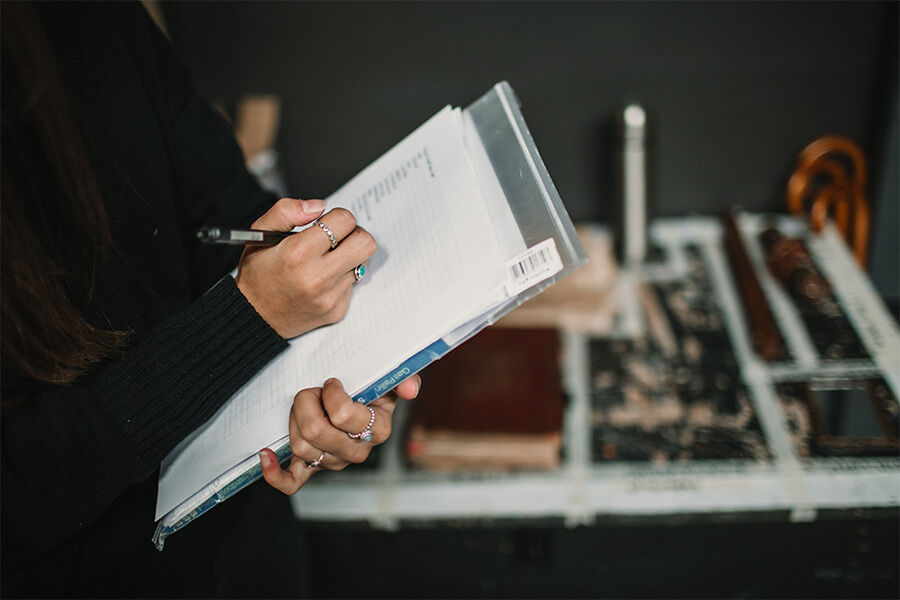 A student is writing on a notepad, and is backstage