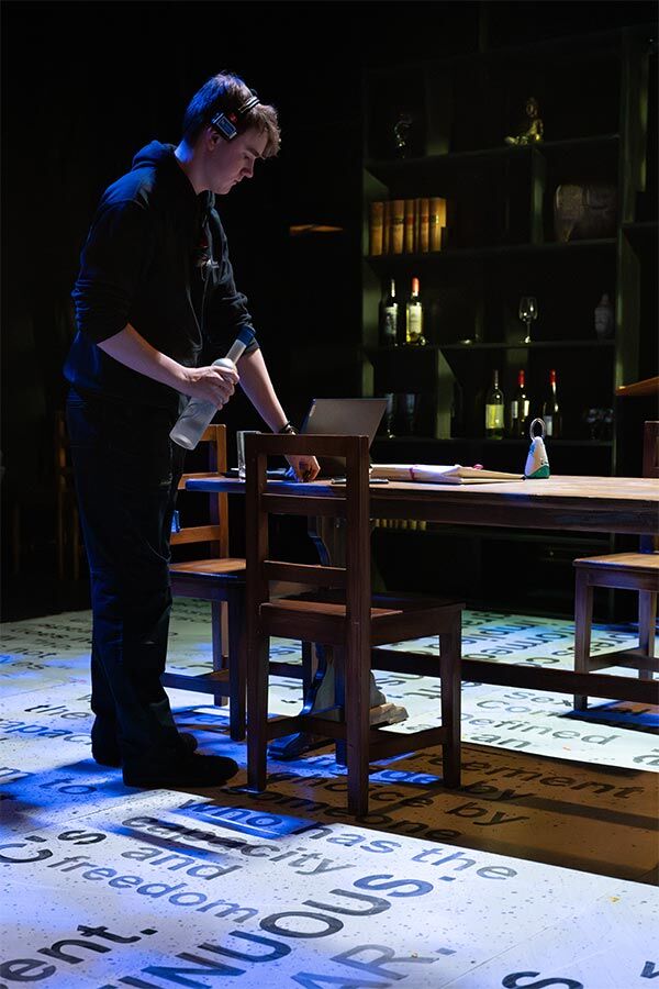 A student is setting up a stage, placing items on a table