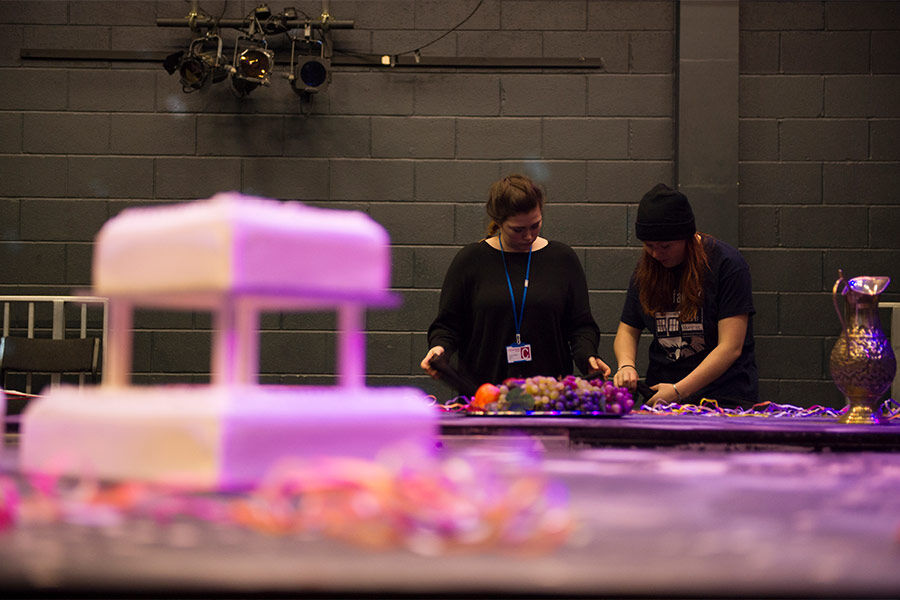 Two students are setting up a prop on a table, backstage