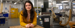Product and Furniture Design student, Amelia Hewitt, poses for a photo in the Furniture Design workshop.
