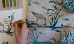 A student's work laid out on a table with various fabrics and drawings