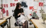 A student sewing a piece of clothing