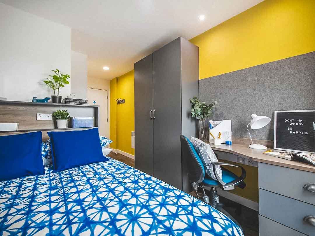 A bed, desk and wardrobe in a bedroom