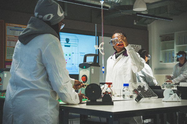 Engineering students measure chemicals in a lab