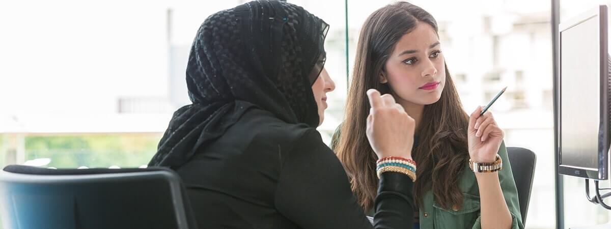Two people discussing what is being shown on a monitor