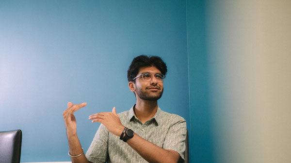 A student talks passionately to someone sitting in a classroom