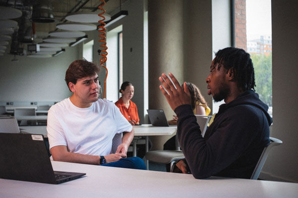 Two students talking in a classroom