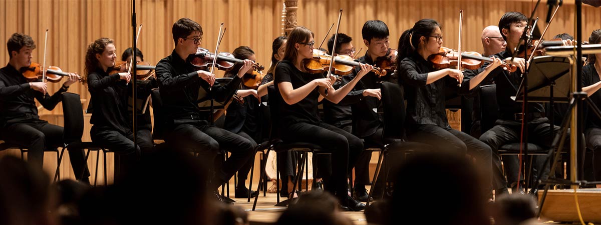 Student violin musicians playing concert