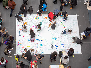 Children and young people take part in a collective drawing exercise at a Birmingham City University Family Day
