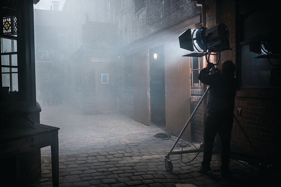 Filming on location on a misty cobblestoned street