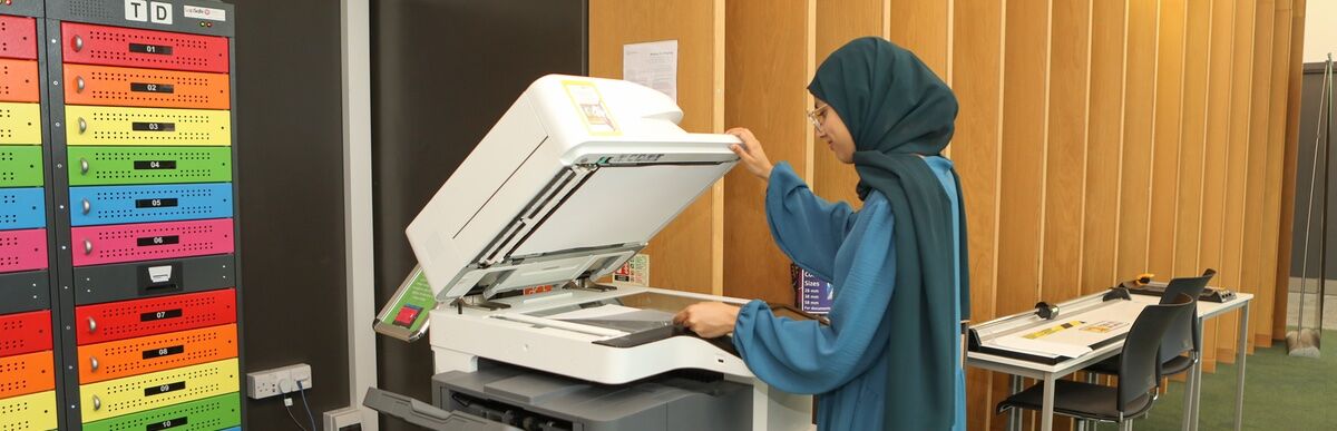 Student using printer in library