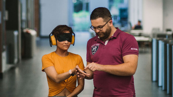 Deafblind person with hands out in a yellow top
