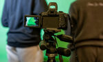 Two students stood in front of a camera