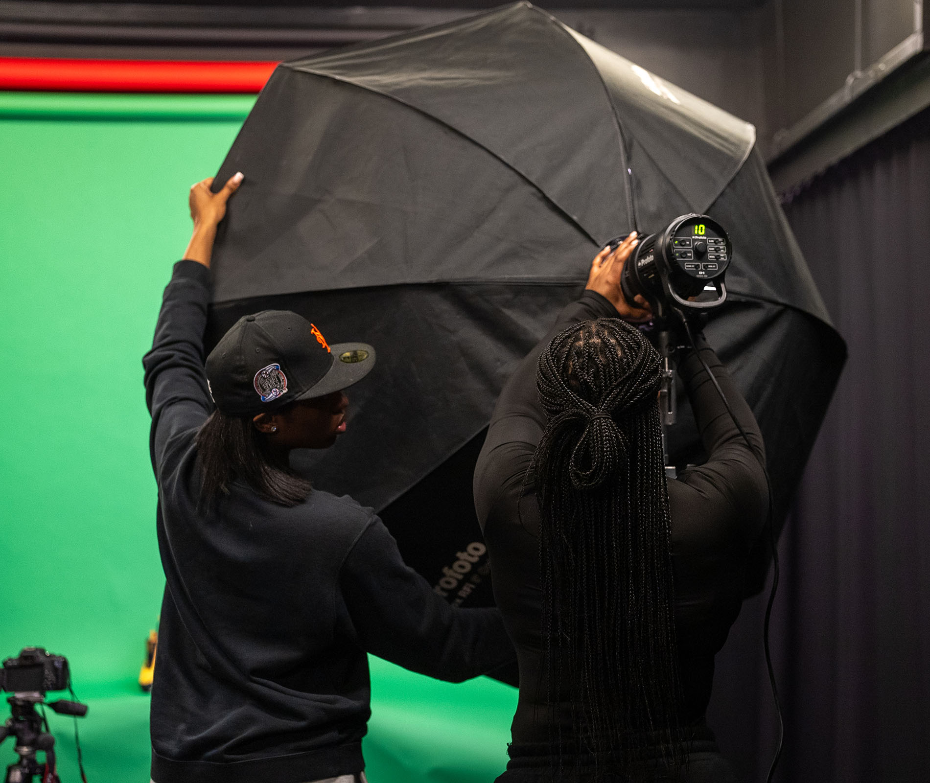 Student setting up lighting equipment