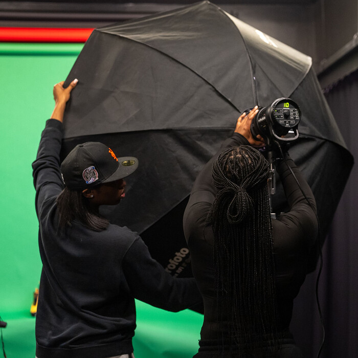 Student setting up lighting equipment