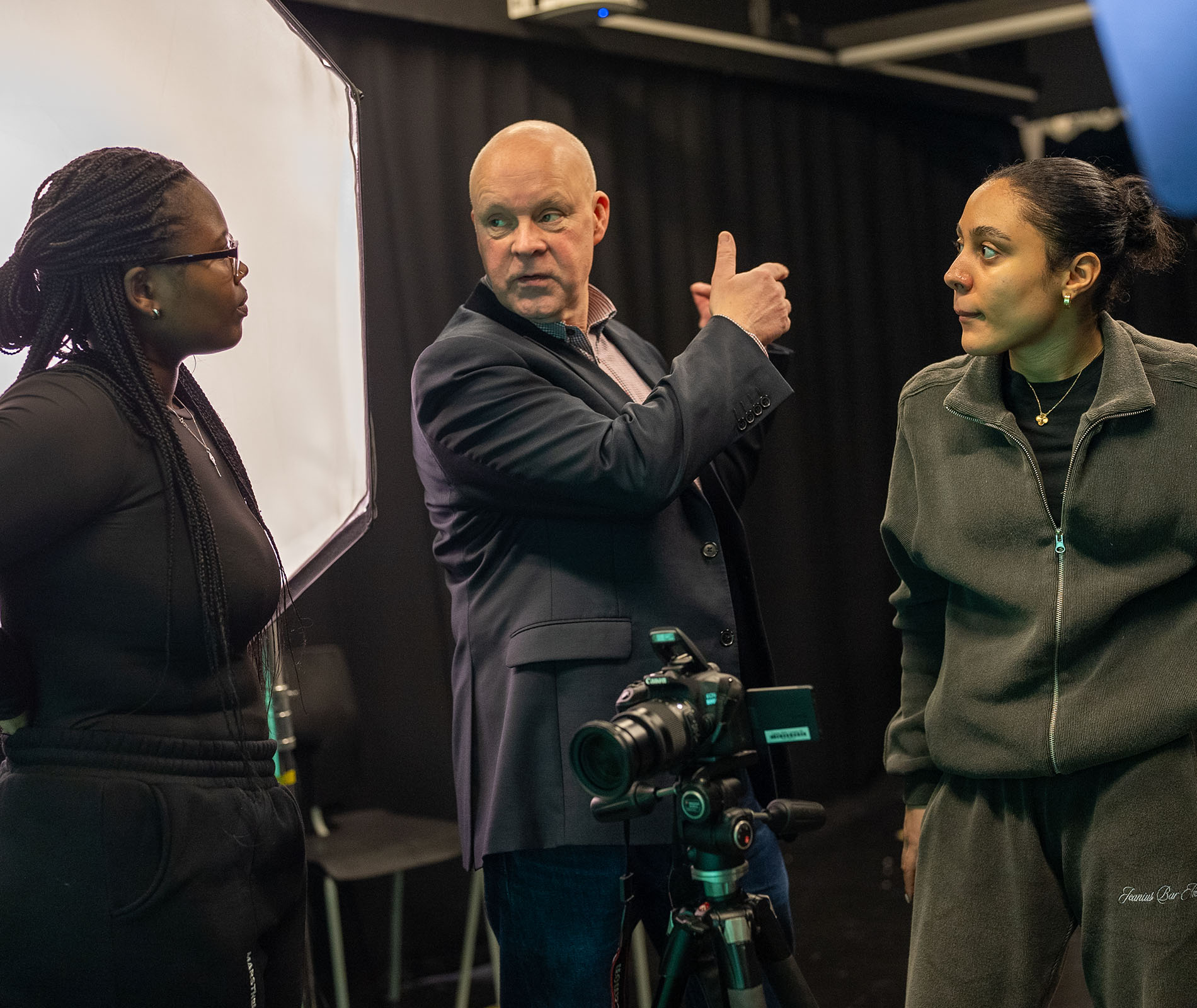 Lecturer talking to students in a studio