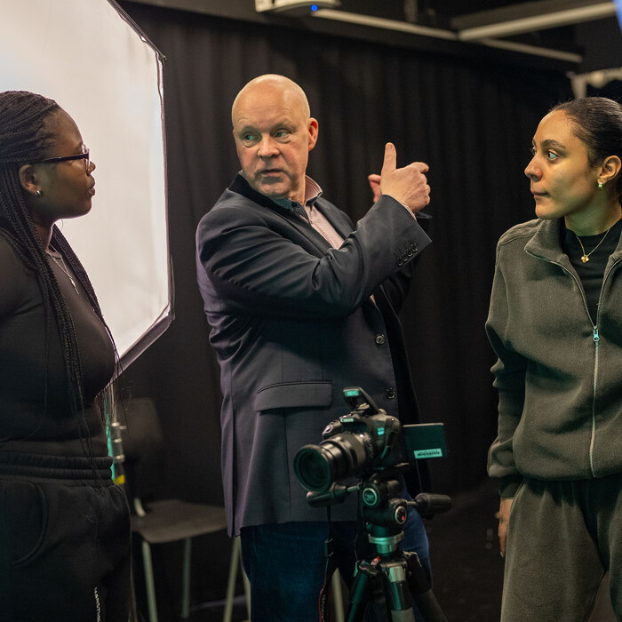 Lecturer talking to students in a studio