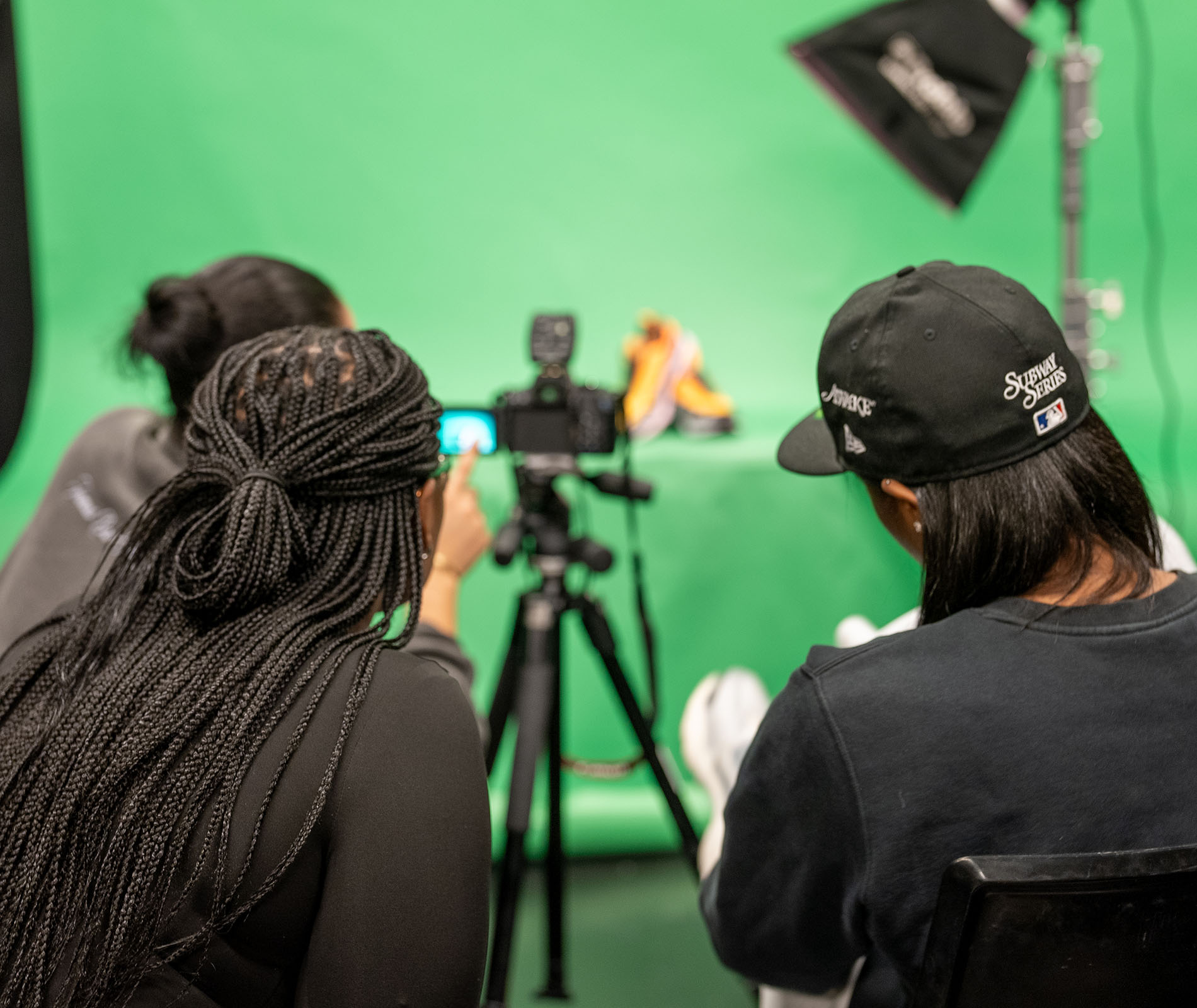 Students using a camera against a green screen