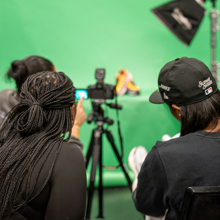 Students using a camera against a green screen
