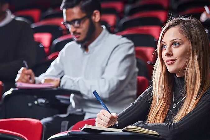 Woman sat in a theatre style classroom