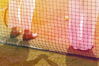 Human legs behind tennis net