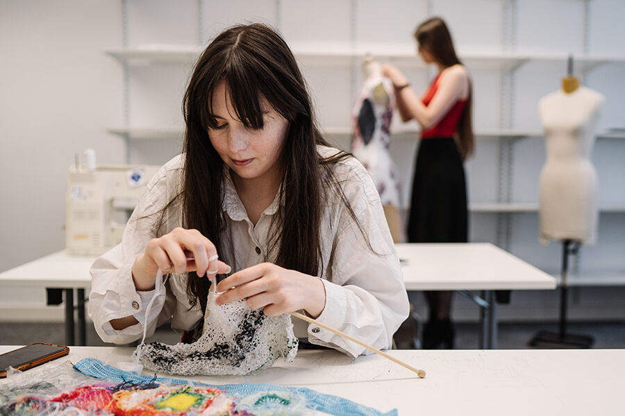 Woman sitting at a table with fabric 