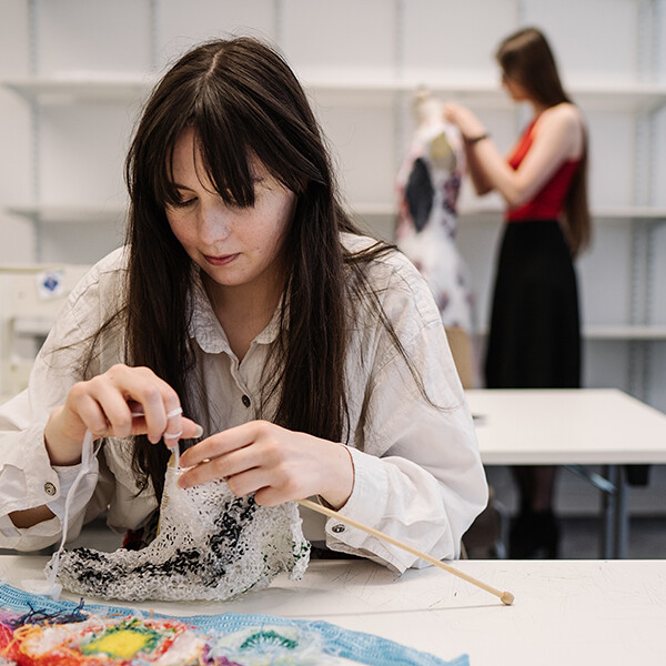 Woman sitting at a table with fabric