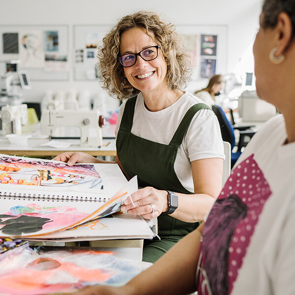 Woman talking to a student over fabric