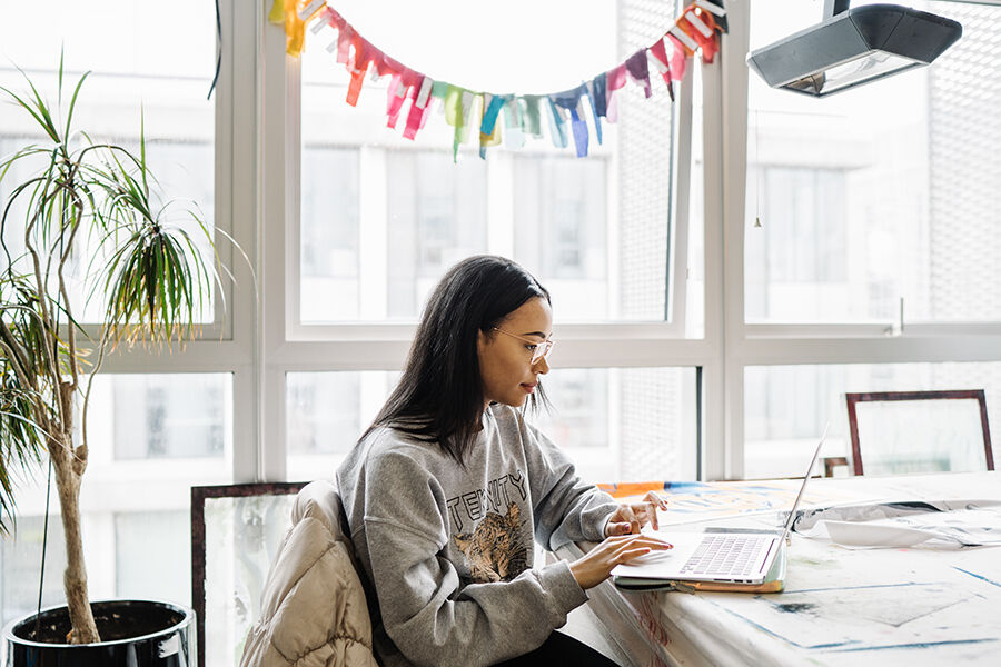 Woman using a laptop in front of a window