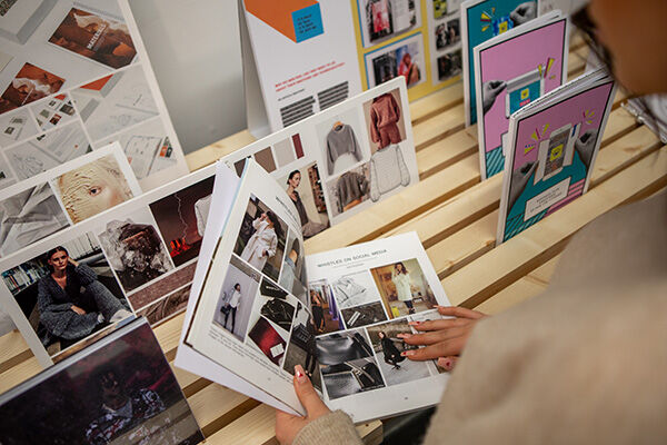Someone is looking through a cool magazine or booklet with lots of pictures of clothes and fashion! It looks like they're checking out different styles.