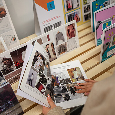 Someone is looking through a cool magazine or booklet with lots of pictures of clothes and fashion! It looks like they're checking out different styles.
