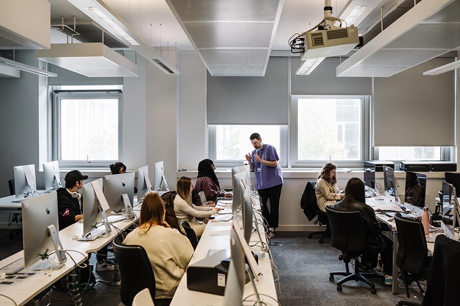 Lecturer in computer lab with students