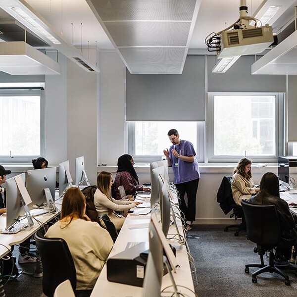 Lecturer in computer lab with students