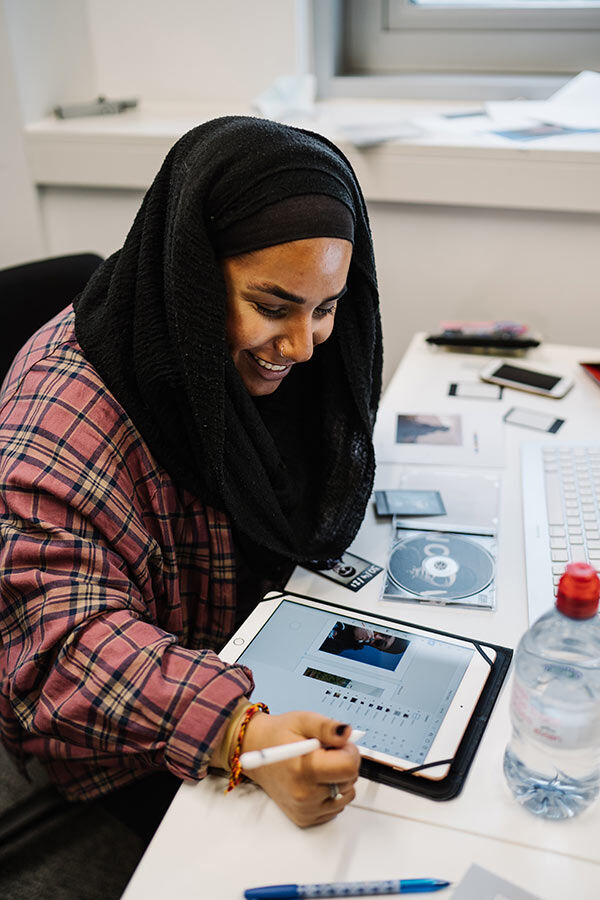 Student working on a design on table using a stylus