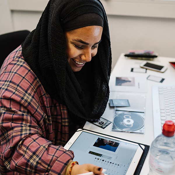 Student working on a design on table using a stylus