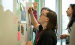 Students using whiteboard and post it notes in lecture