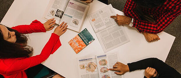 3 students sat around table working on Forensic Psychology task