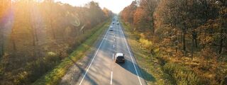 Aerial shot of cars driving on countryside road