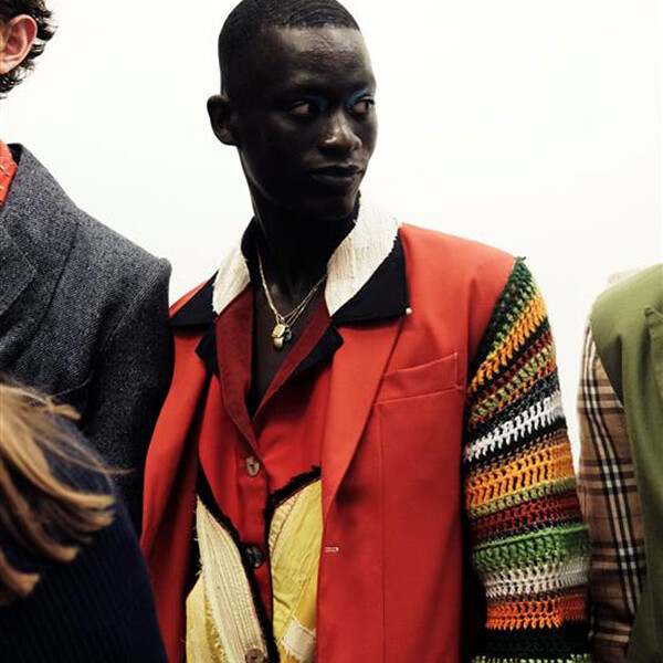 Student in bright coloured shirt and jacket, including orange and yellow shades