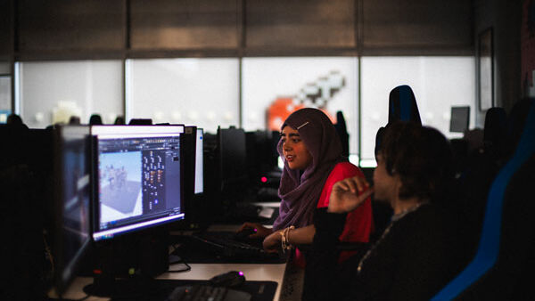Two students working on computers in the games lab