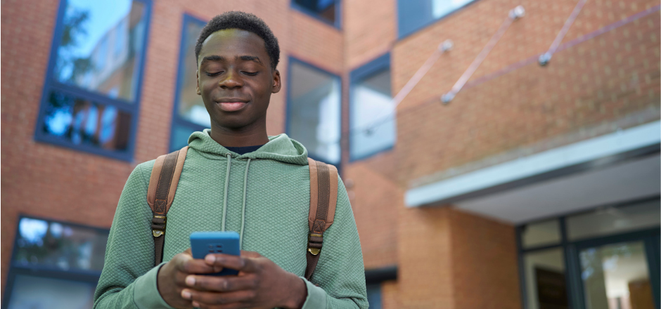 A Black student looks for jobs on his phone.