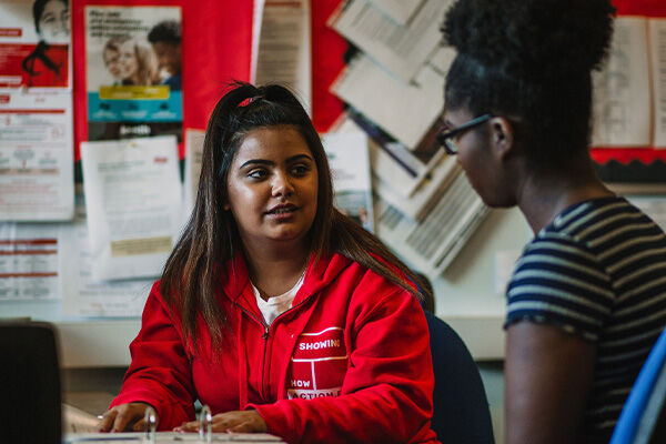two women sat in red jumpers