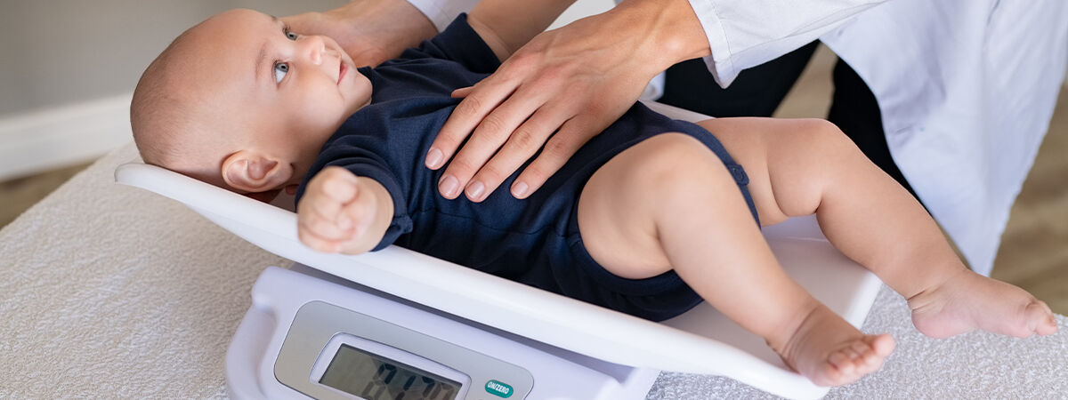 Health visitor weighing baby