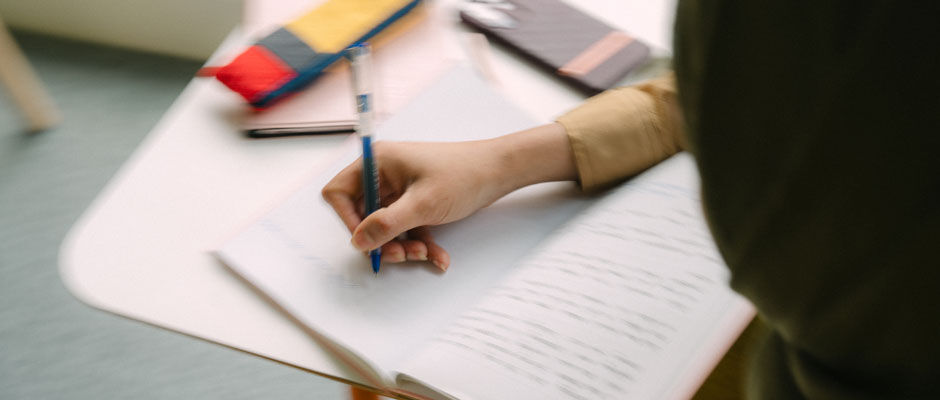 Blurred image of student writing in a notebook
