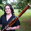 Learning and Participation student Emma Crooks holding woodwind instrument, stood outside smiling